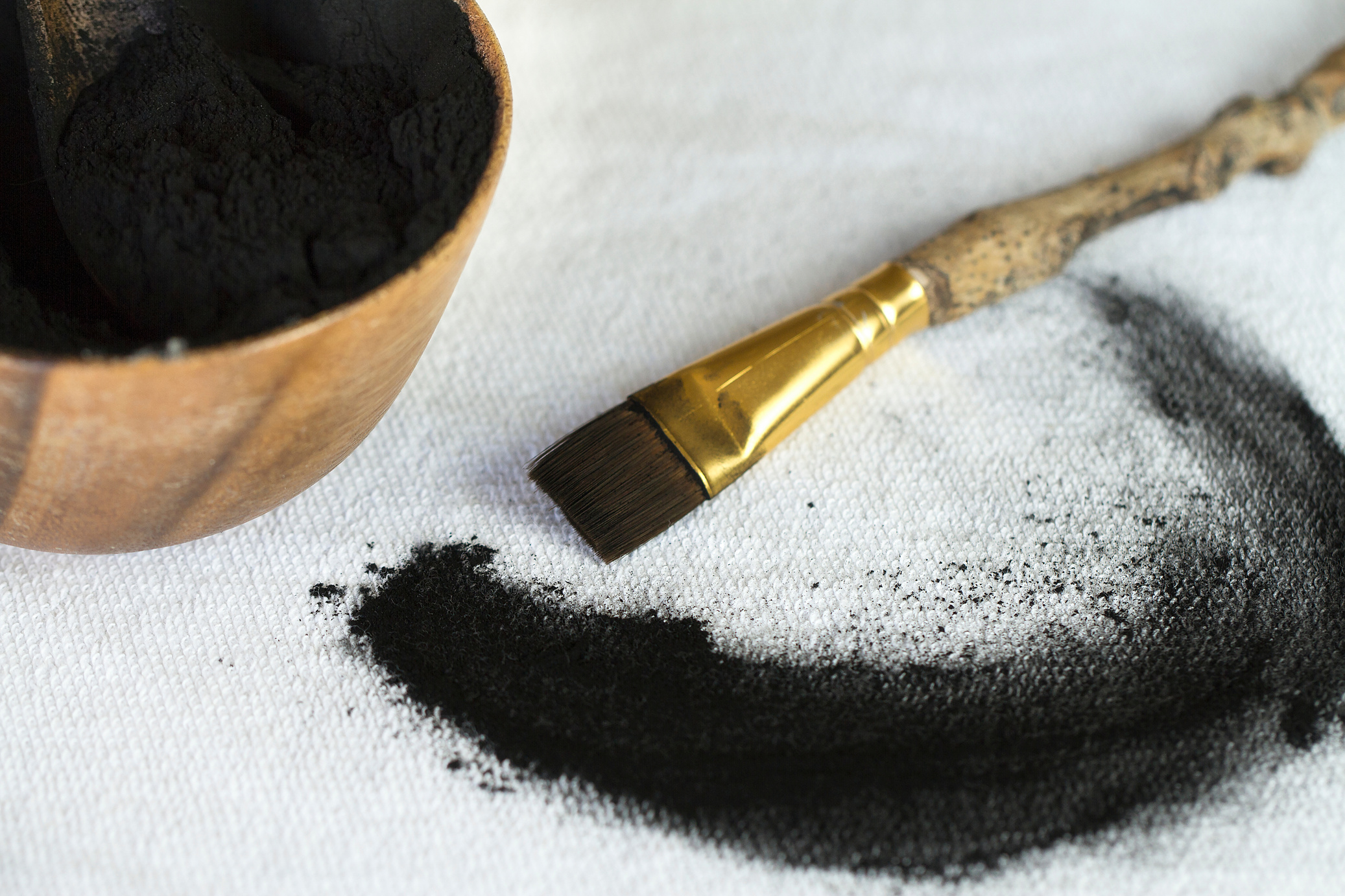 Activated Charcoal Powder and a Natural Wooden Branch Brush for Application